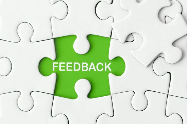 Ein grünes Puzzlestück mit dem Wort "Feedback" fügt sich harmonisch in weiße Teile ein und symbolisiert Patientenfeedback.